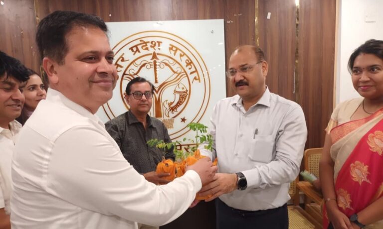 बैठक में अधीनस्थों को मोरिंगा के पौधे भेंट करते मेरठ जिलाधिकारी डॉ वी के सिंह