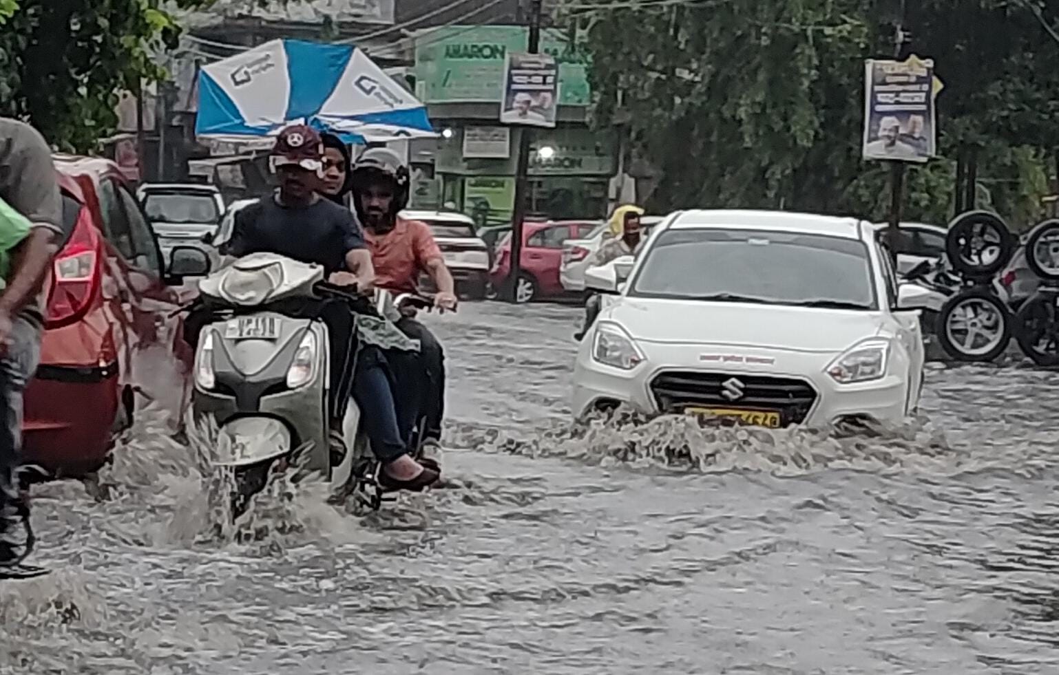 मेरठ के बच्चा पार्क स्थित क्षेत्र से बारिश के दौरान हुए जलभराव से निकलते लोग