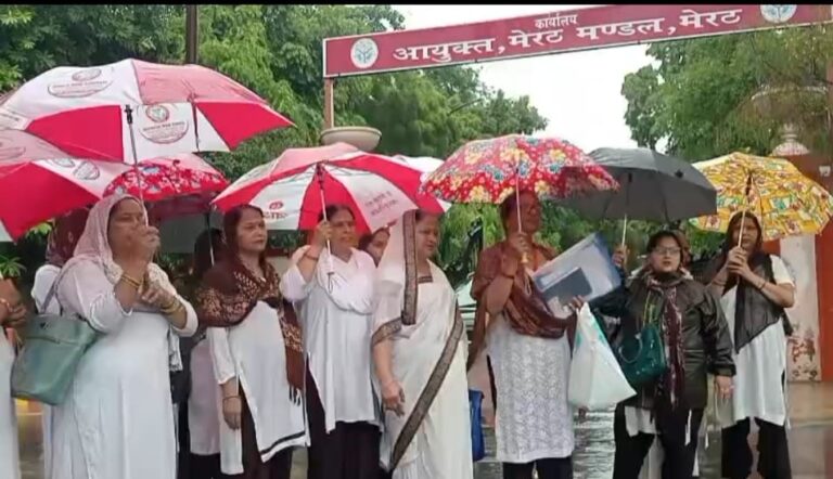 अपनी मांगों को लेकर बारिश में प्रदर्शन करती आशा कार्य कार्यकर्ता