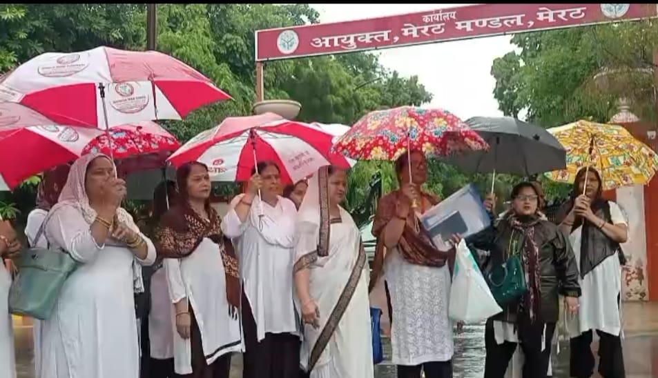 अपनी मांगों को लेकर बारिश में प्रदर्शन करती आशा कार्य कार्यकर्ता