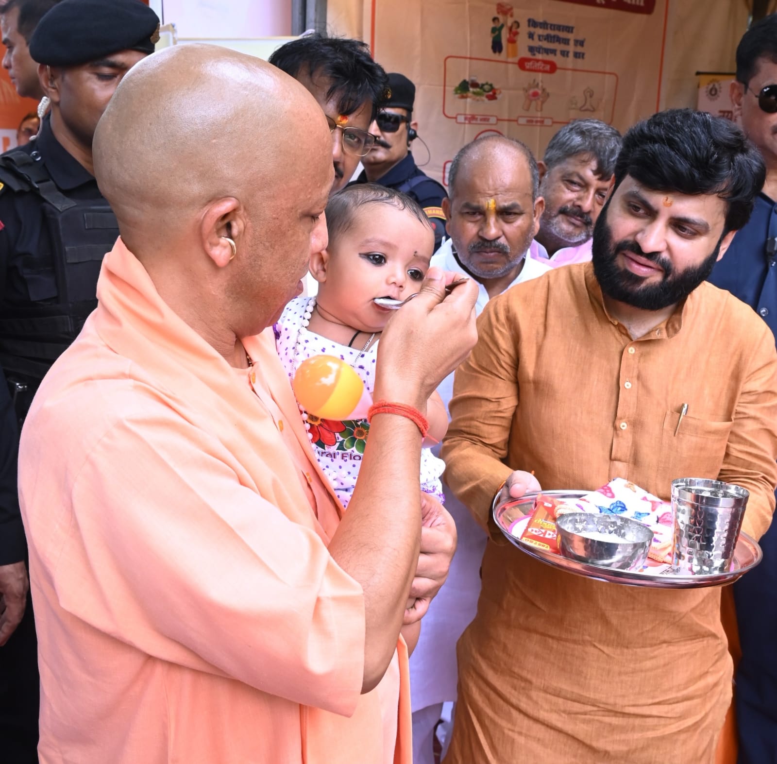 नन्हे बच्चे का अन्नप्राशन कराते उत्तर प्रदेश मुख्यमंत्री योगी आदित्यनाथ