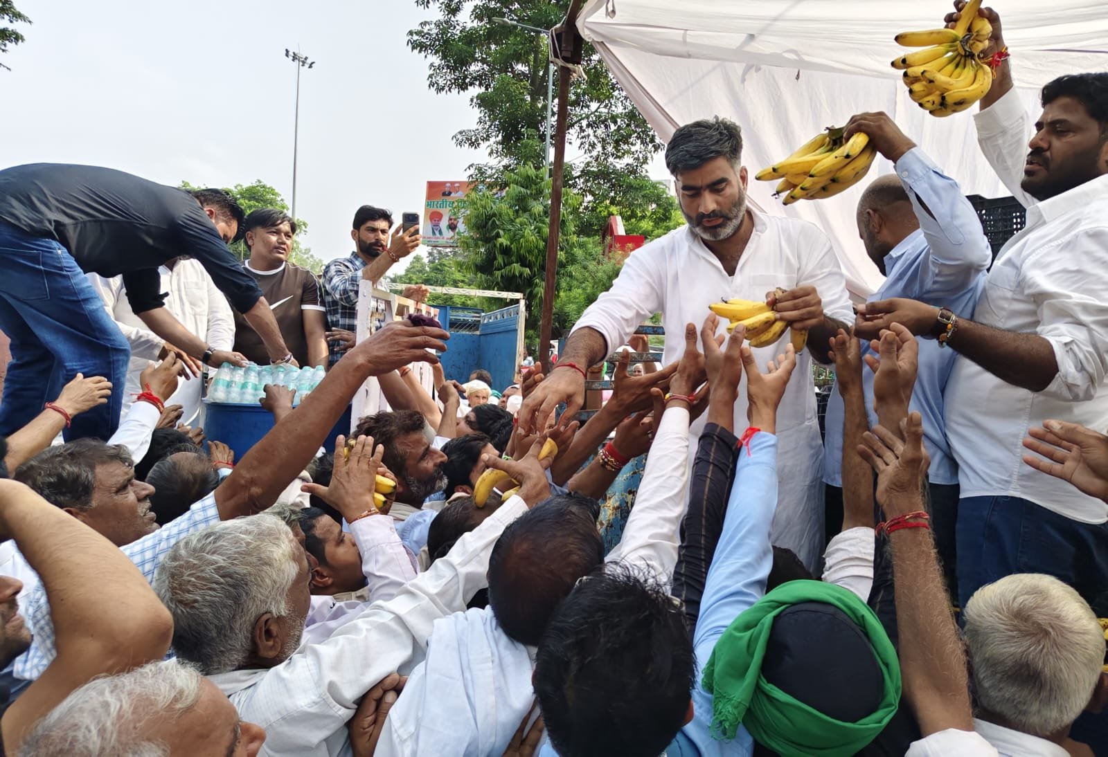 कमिश्नरी पार्क में चल रहे आंदोलन में किसानों को फल वितरित करते सपा विधायक अतुल प्रधान