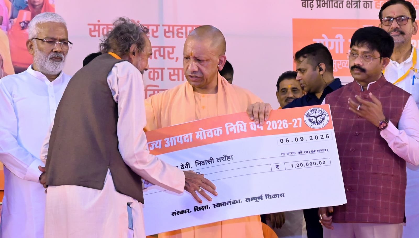 बाढ़ पीड़ितों को राहत चेक सौंपते उत्तर प्रदेश मुख्यमंत्री योगी आदित्यनाथ